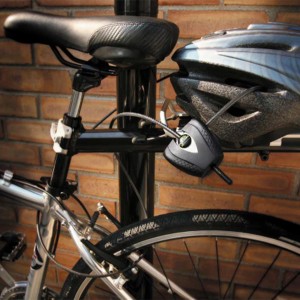 Schwarzes Master Lock Kabelschloss Python am Fahrrad befestigt, sichert Helm.