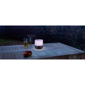 LED Akku-Tischleuchte Tropea mit Farbwechsel auf Holztisch im Garten.