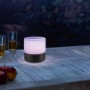 LED Akku-Tischleuchte Tropea mit Farbwechsel auf Holztisch im Garten.
