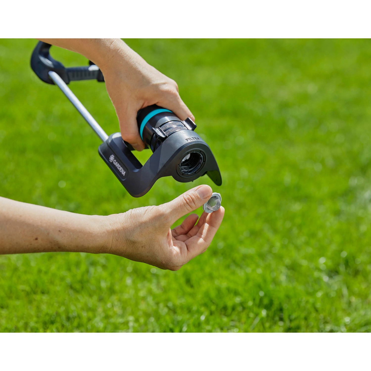 Gardena EcoLine Viereckregner: Hand entfernt Filter zur Reinigung auf Rasen.