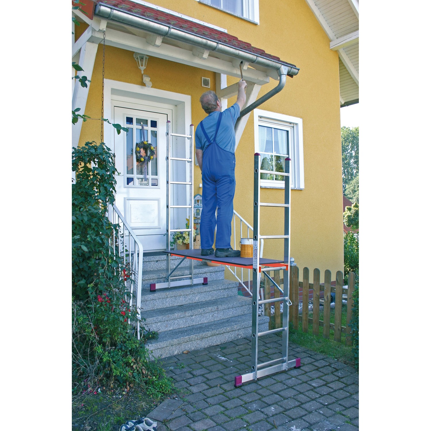 Krause Corda Leiter-Gerüst mit Person beim Anstreichen einer Hauswand auf einer Arbeitsbühne.