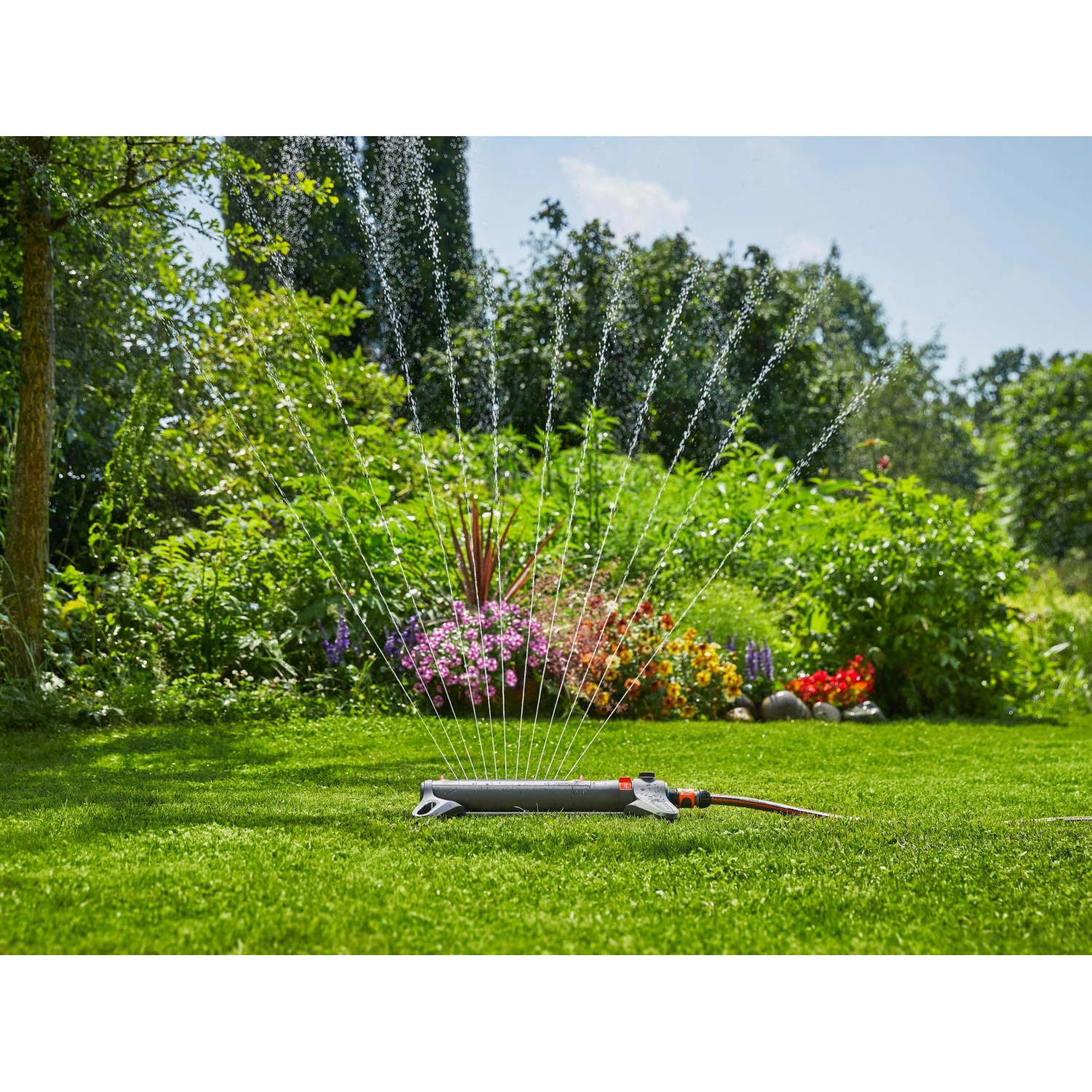 Gardena AquaZoom S Viereckregner bewässert Rasenfläche im Garten.