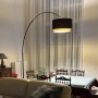 Moderne Bogenleuchte in Schwarz mit Duo-Schirm (schwarz/gold) im Wohnzimmer.