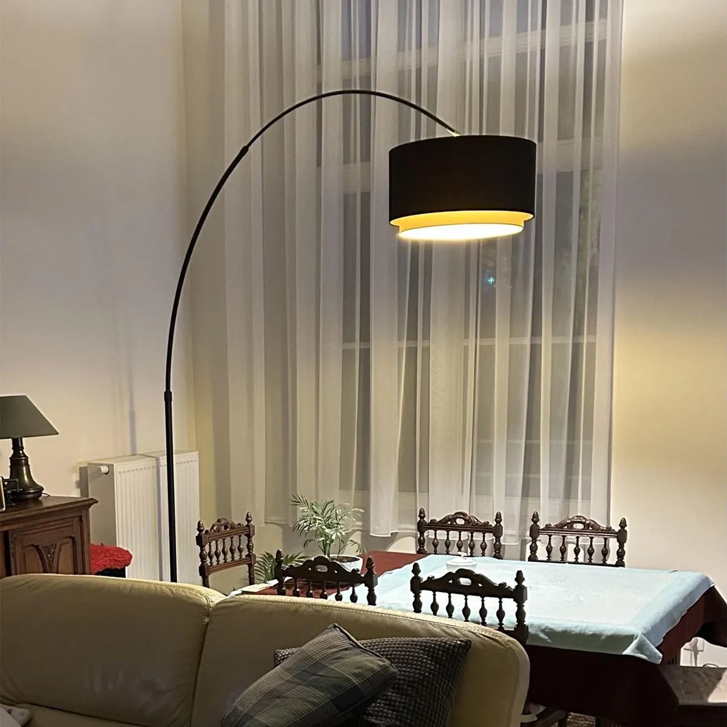 Moderne Bogenleuchte in Schwarz mit Duo-Schirm (schwarz/gold) im Wohnzimmer.