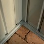Detailaufnahme: Ecke des anthrazitfarbenen Globel Metall-Anlehngerätehauses mit Bodenbefestigung.