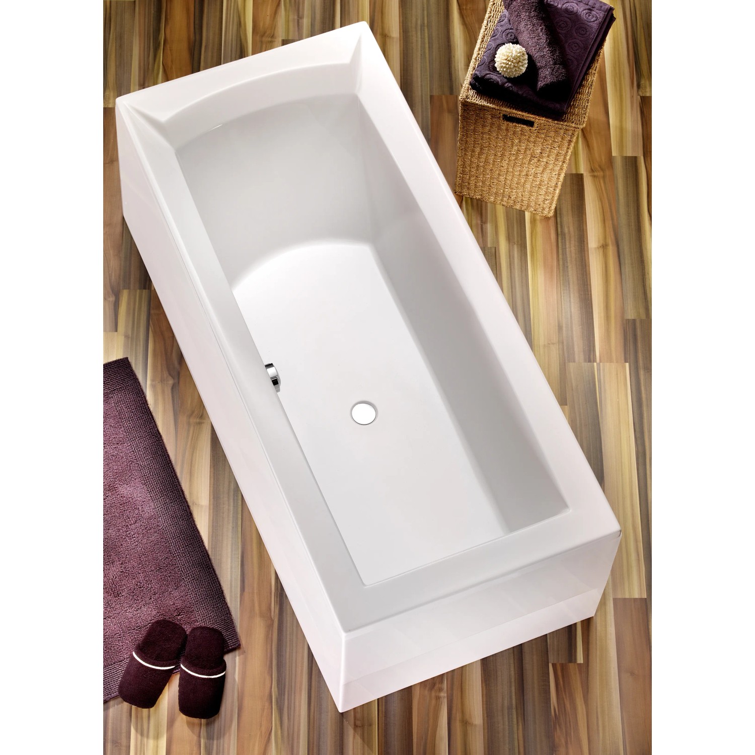 Rechteckige, weiße Badewanne Porta 180x80 cm mit Ablauf in der Mitte, umgeben von Bad-Accessoires.