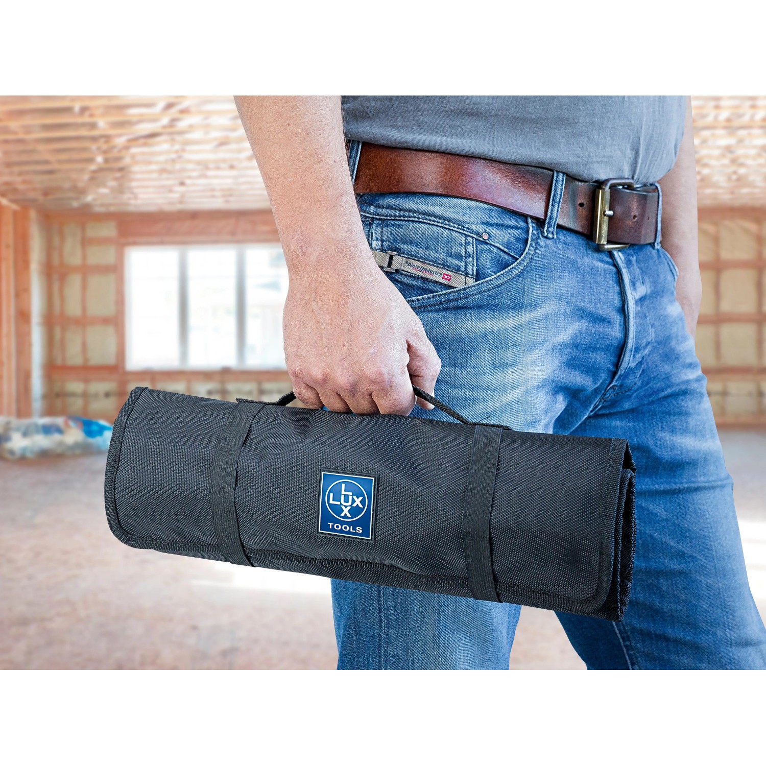 Mann trägt gerollte LUX Werkzeugtasche mit 26 Fächern. Praktische Arbeitsgürtel-Tasche.