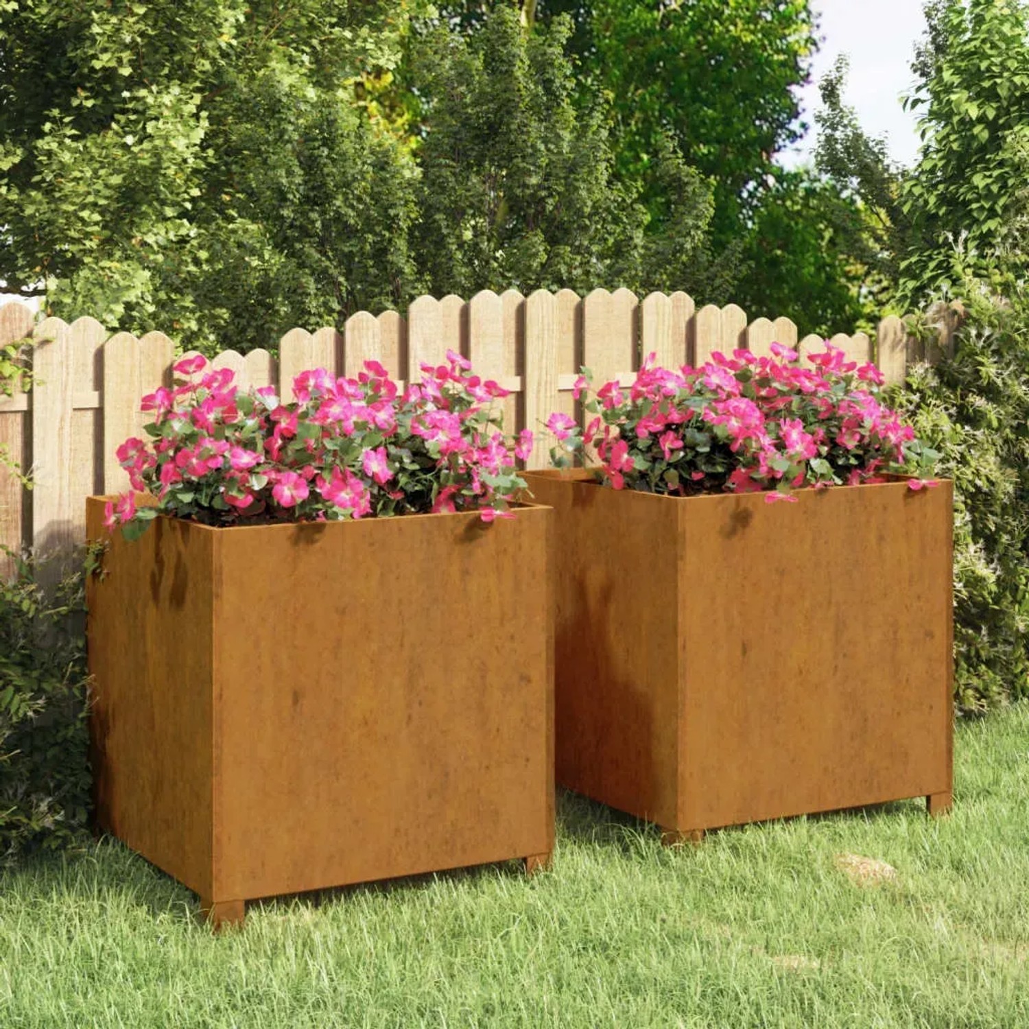 Zwei quadratische Pflanzkübel aus Cortenstahl mit rostiger Optik und Beinen, gefüllt mit pinken Blumen im Garten.