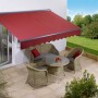 Hülsenmarkise Bedford, 4x2,5m, Berryrot, montiert an einer Hauswand über einer Terrassentür.