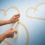 Anwendung von LUX Hochkrepp Klebeband (Beige, 50mm) zum Abkleben von Wolken an einer Wand.