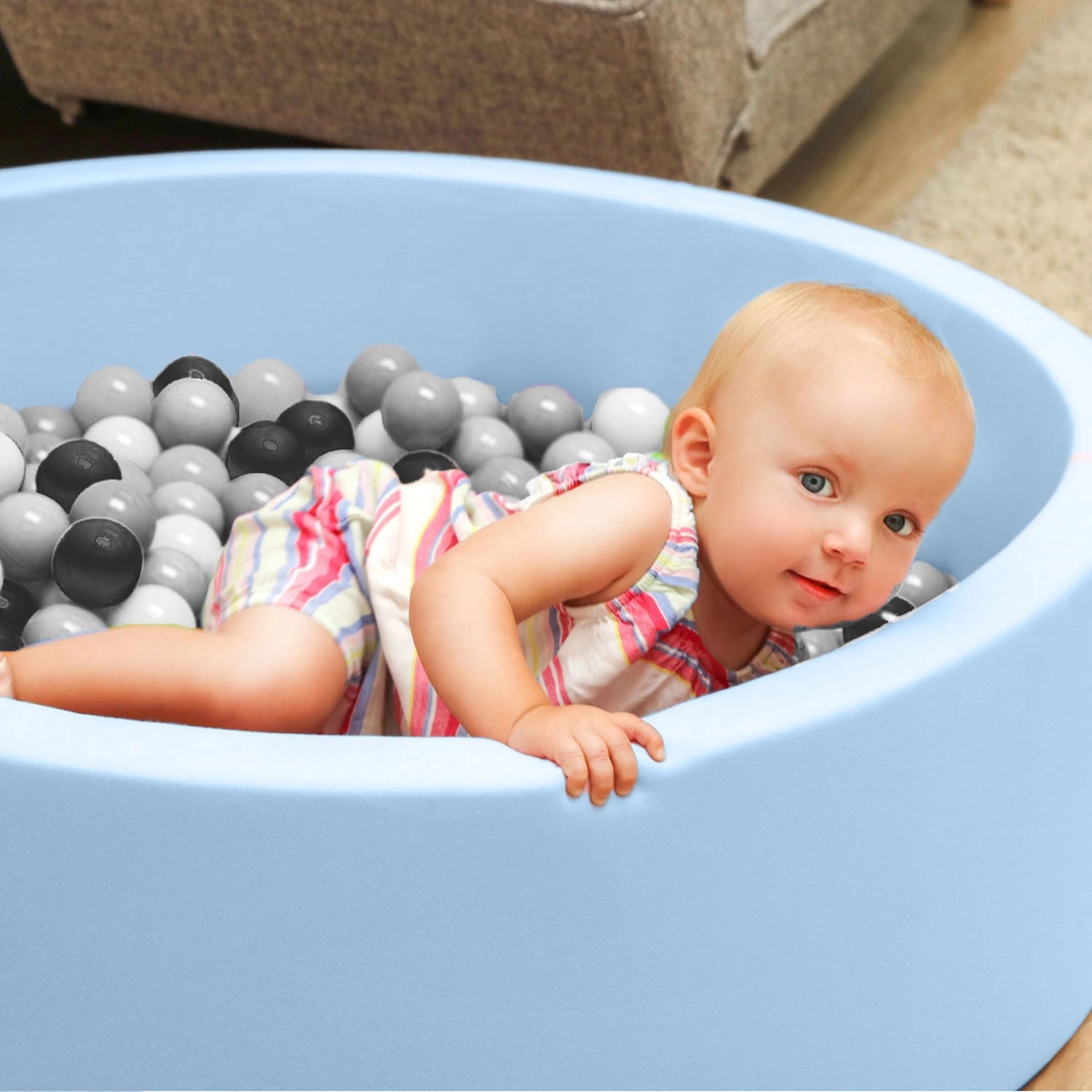 Baby im Bällebad mit LittleTom Bällebadbällen in Schwarz, Grau, Weiß und Transparent.