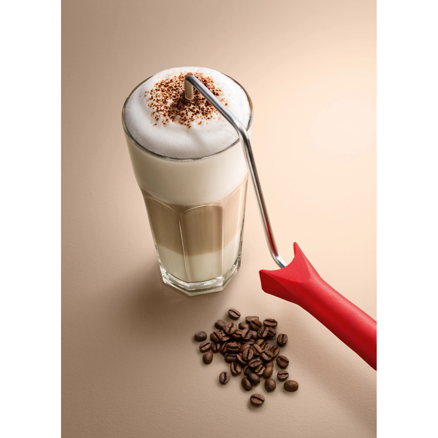 Schöner Wohnen Trendfarbe Macchiato: Matte Wandfarbe im Farbton eines Latte Macchiato mit Farbroller und Kaffeebohnen.