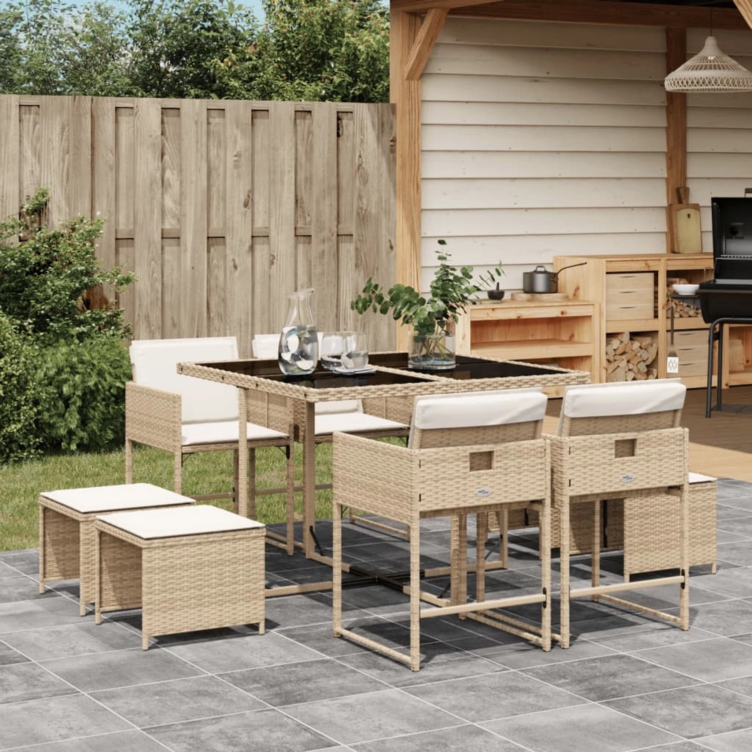 Beige 9-tlg. Garten Essgruppe aus Polyrattan mit schwarzen Glas Tischplatte und cremefarbenen Kissen.