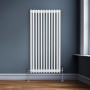 Weißer 3-Säulen Heizkörper (150x56,2cm) im traditionellen Design vor blauer Wand.