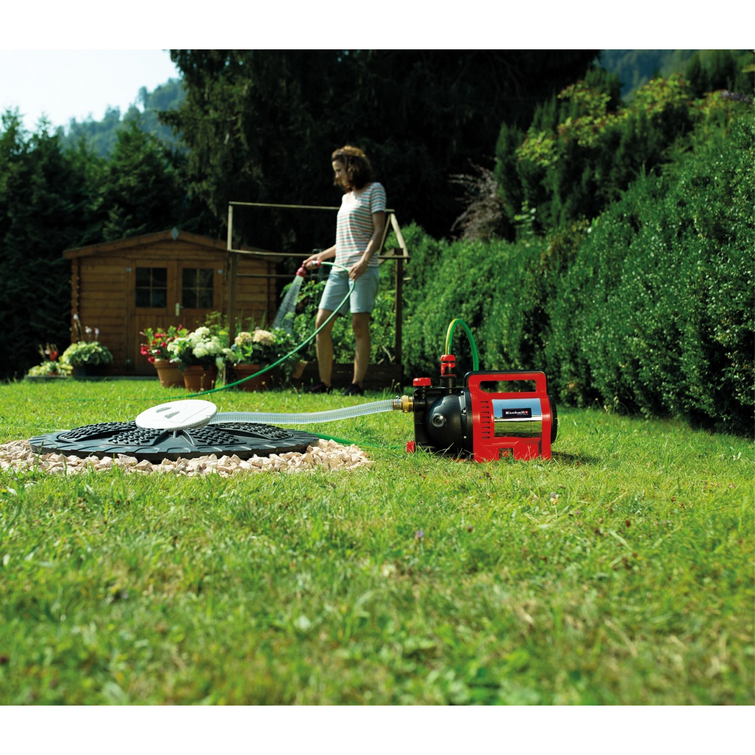 Einhell GC-GP 1250 N Gartenpumpe im Einsatz: Frau bewässert Garten mit der Elektro-Pumpe.