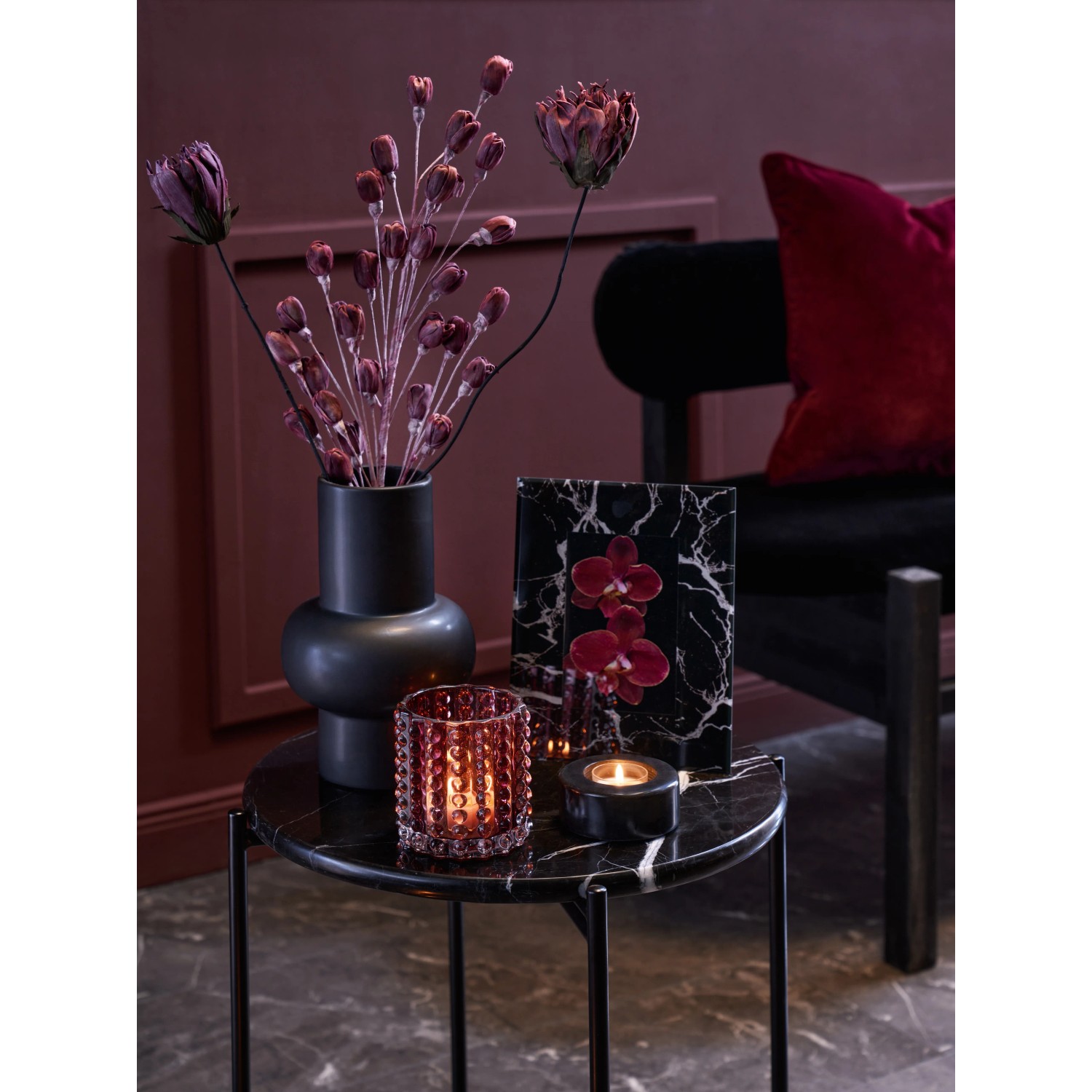 Schwarze Vase Midnight Mystery mit Deko-Elementen auf einem Tisch. Elegantes Design.
