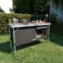 Faltbare 24MOVE Campingküche Praia mit Alurahmen, Arbeitsplatte und Tragetasche im Garten.
