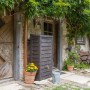 Arves Regentonne Norway 230 l, dunkelbraun, im Garten vor Hauswand mit Pflanzen.