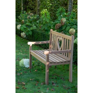 Gartenbank Herz aus Teakholz mit Herzmotiv im Garten.