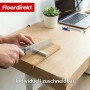 Hände sägen weißen Floordirekt Kabelkanal auf Holzplatte. Zuschneidbare, selbstklebende Kabelleiste für Büro & Homeoffice.
