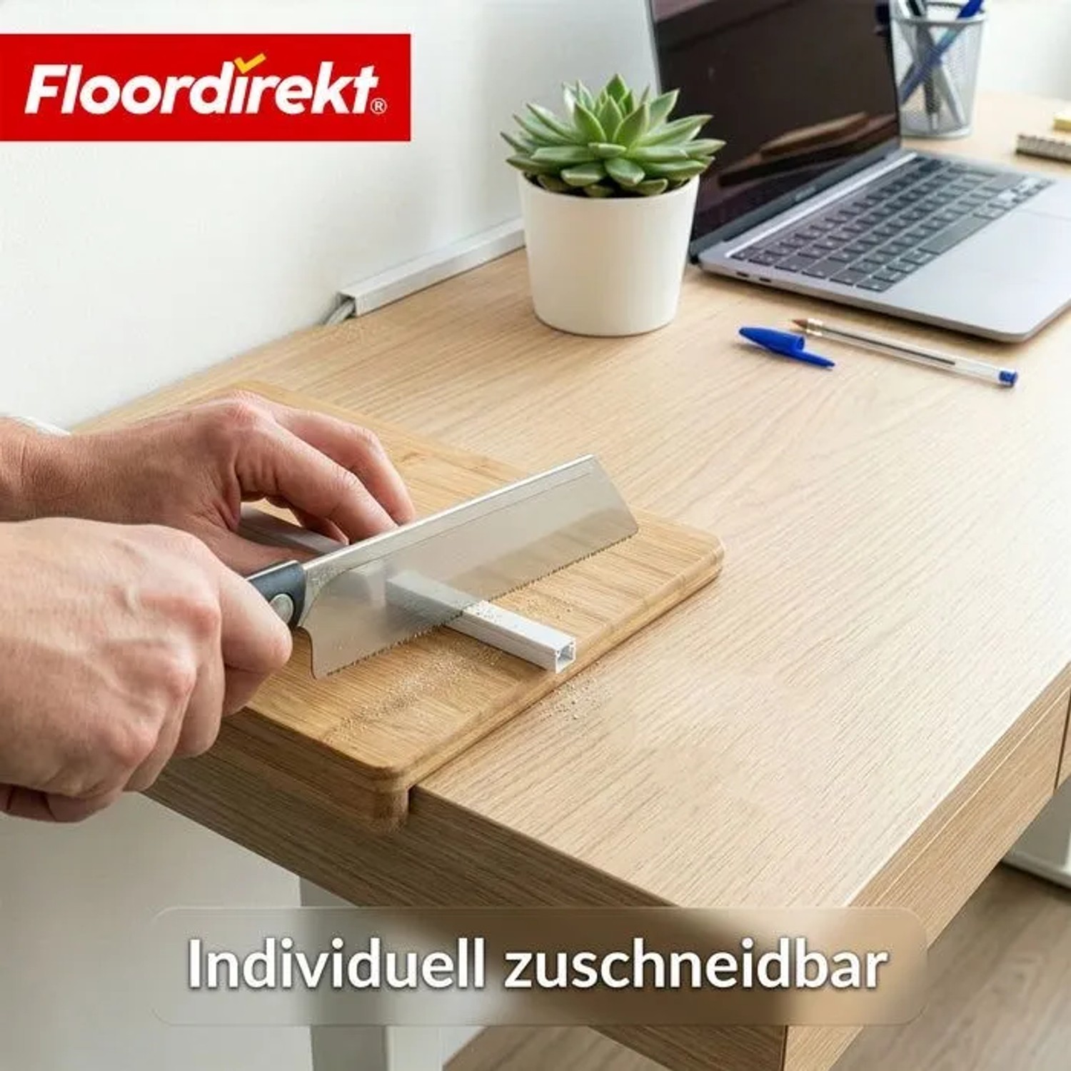 Hände sägen weißen Floordirekt Kabelkanal auf Holzplatte. Zuschneidbare, selbstklebende Kabelleiste für Büro & Homeoffice.