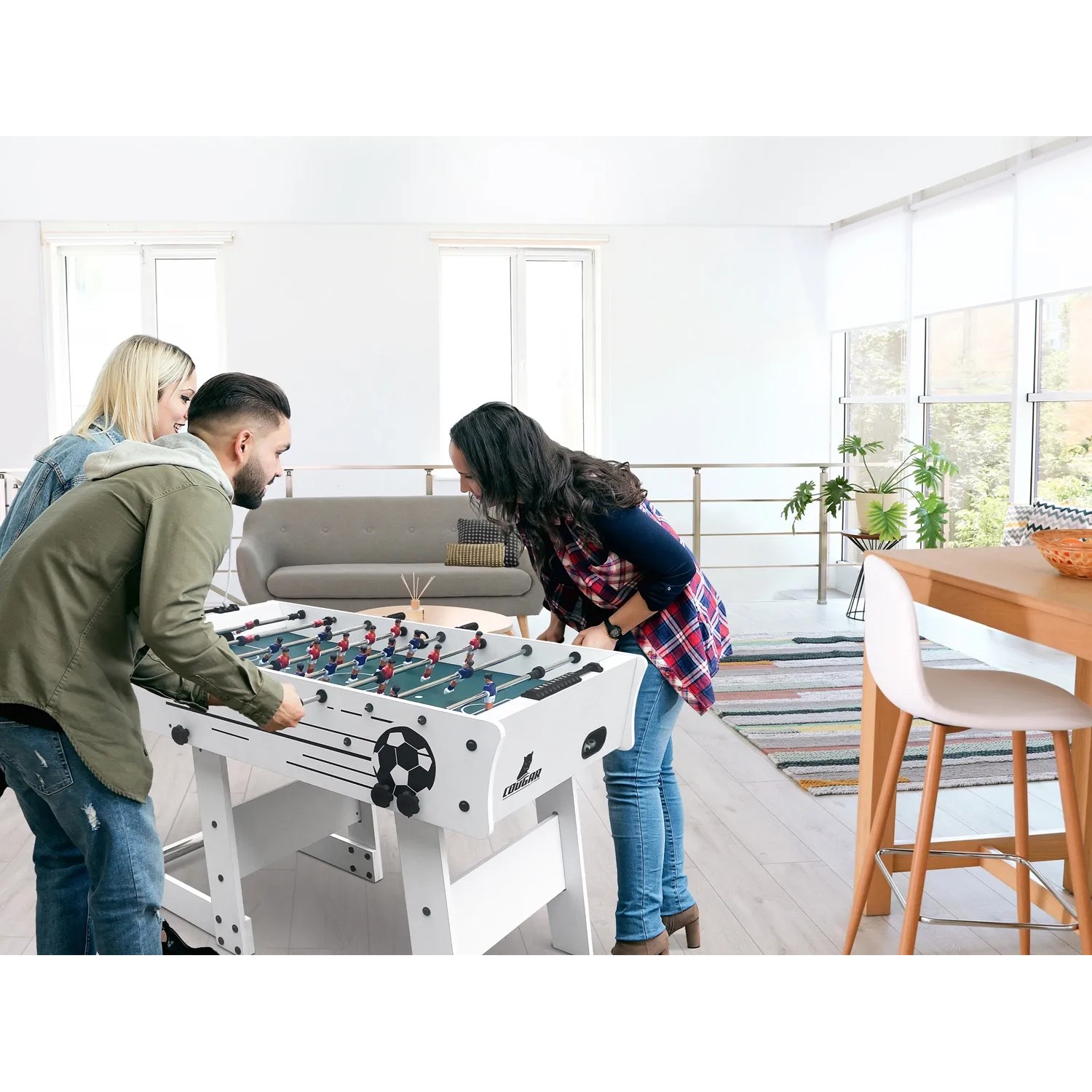 Cougar Tischkicker Scorpion Kick TS (faltbar, weiß) mit spielenden Personen.