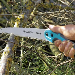 Gardena Gartensäge 300 P beim Sägen eines Astes. Handsäge mit blau-grauem Griff.