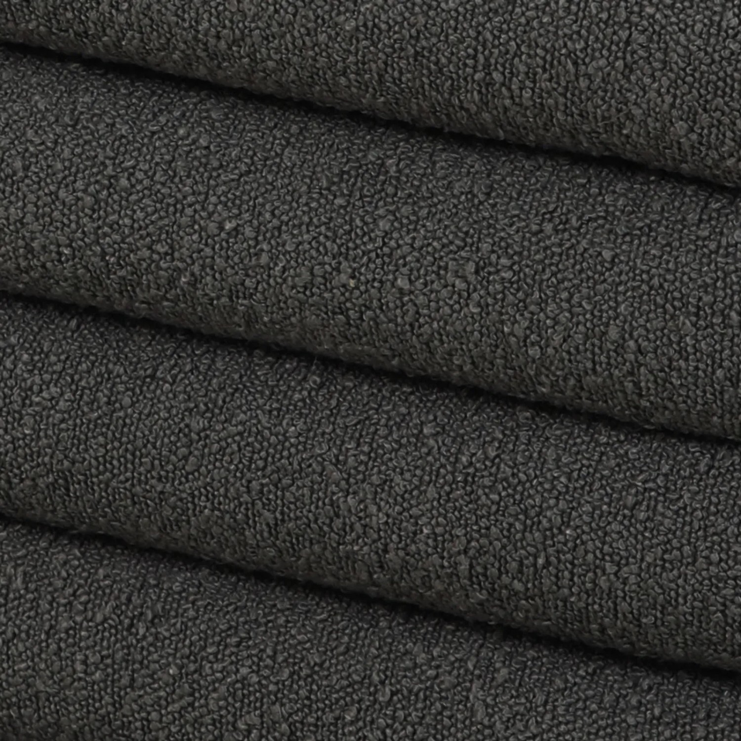 Detailaufnahme des dunkelgrauen Teddybouclé-Stoffs vom Svita Blossom XL Hocker.