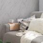 Graue A.S. Création Vliestapete in Marmoroptik an Wohnzimmerwand hinter Couch mit Kissen und Decke.