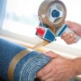 Braunes LUX Packband 50mm x 66m in Verwendung auf einer blauen Rolle.