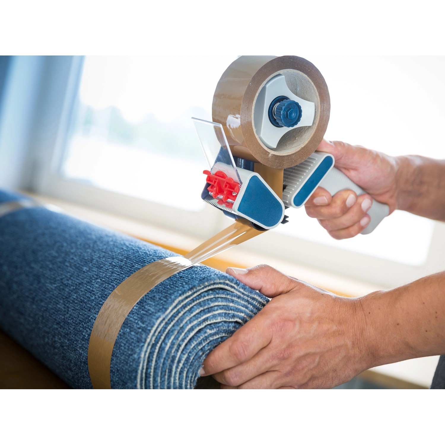 Braunes LUX Packband 50mm x 66m in Verwendung auf einer blauen Rolle.