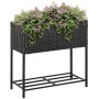 Outsunny Blumenkasten aus Rattan mit Füßen und Ablage, bepflanzt mit lila Blüten.