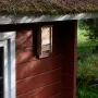 Wild Yard Fledermaushaus aus Zedernholz am roten Holzhaus. Vogelhaus für bis zu 50 Fledermäuse.