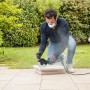 Mann arbeitet mit Bosch UniversalGrind 850-125 Winkelschleifer an Steinplatten im Garten.