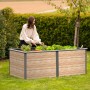Westmann Hochbeet Primus-Multi, 2x1m, anthrazit/holzoptik. Frau bepflanzt das Metall-Hochbeet im Garten.