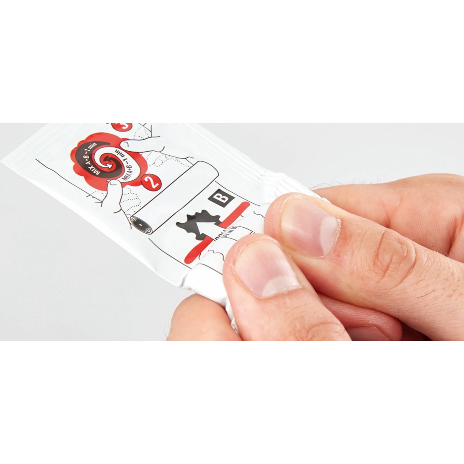 Detailaufnahme: Hand öffnet Fischer Kleber für Klebehaken. Anleitung auf der Packung.