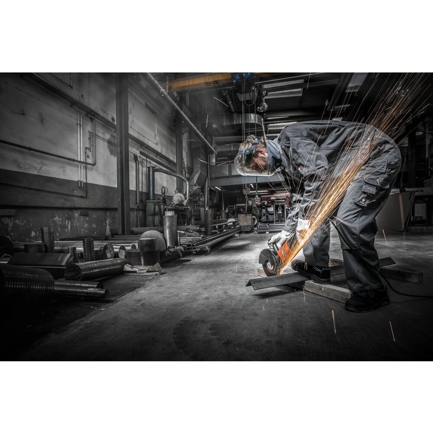 Anwender beim Schneiden von Stahl mit einer Pferd Trennscheibe am Winkelschleifer. Funken fliegen.