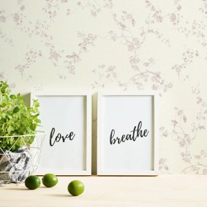 Florale Vliestapete in Creme-Rosa mit Kirschblüten-Design für ein romantisches Ambiente.