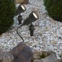 Briloner LED-Gartenspieß-Leuchten im Garten, zwischen Steinen und Pflanzen.
