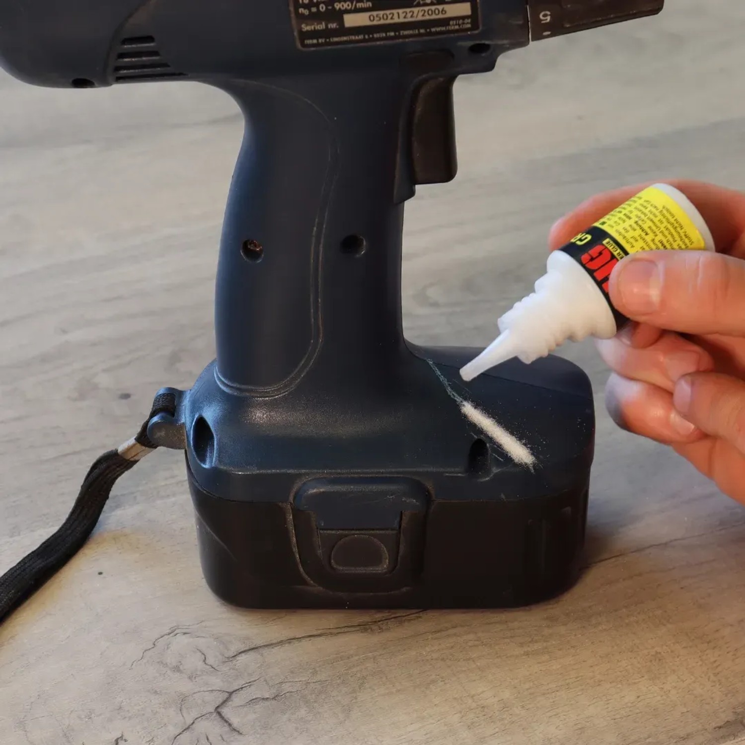 Anwendung von HG Power Glue Haftvermittler auf einem Akkuschrauber. Kleber für Kunststoff.