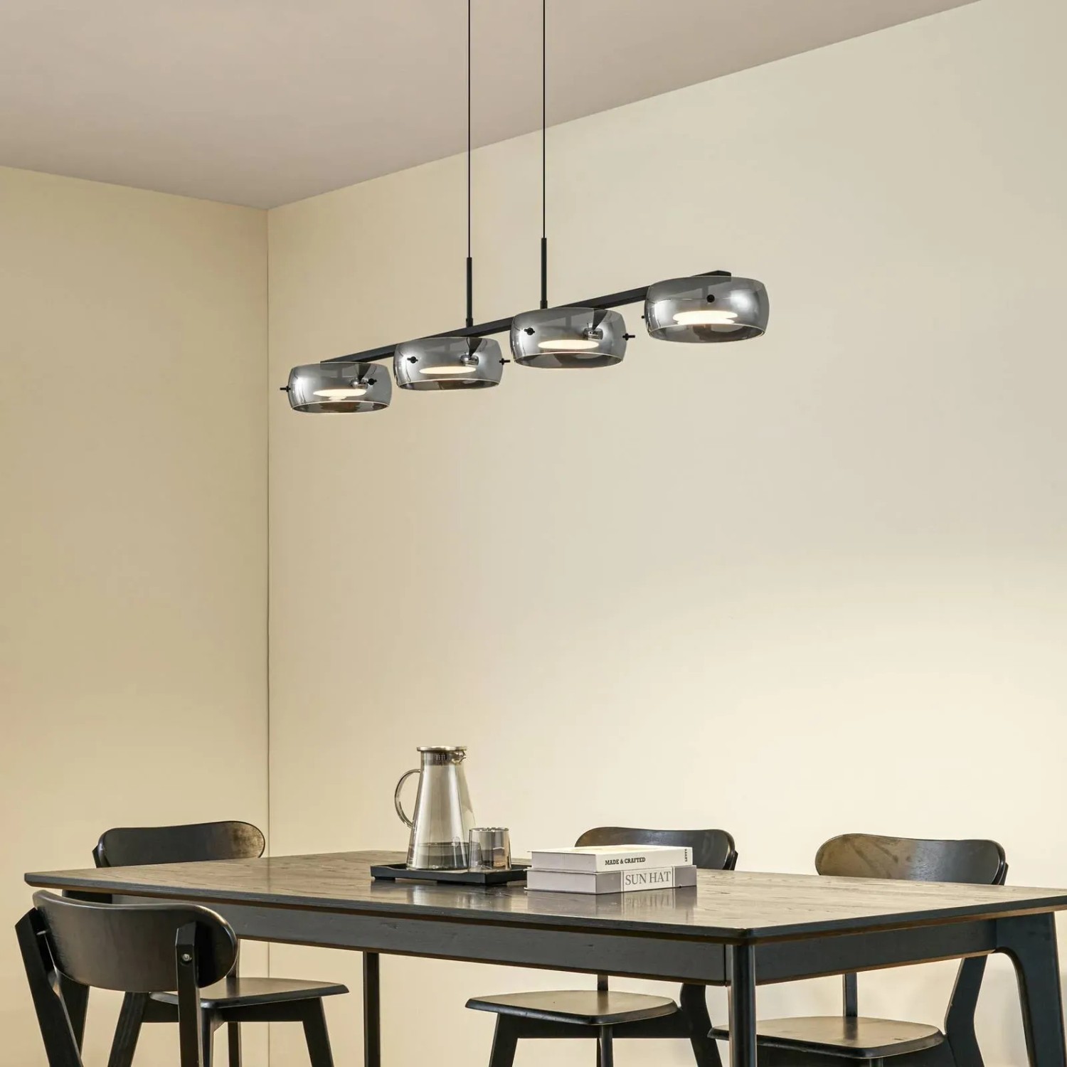 Moderne Lucande LED Pendelleuchte Martis, 4-flammig, schwarz mit Rauchglas, dimmbar, über Esstisch.