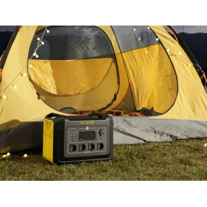 Tragbare Elecfull Powerstation, schwarz-gelb, mit Display und Anschlüssen, vor Zelt auf Gras. Ideal für Outdoor.