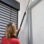Frau benutzt Gardena combisystem Winkelbesen mit Stiel zur Reinigung einer Ecke.