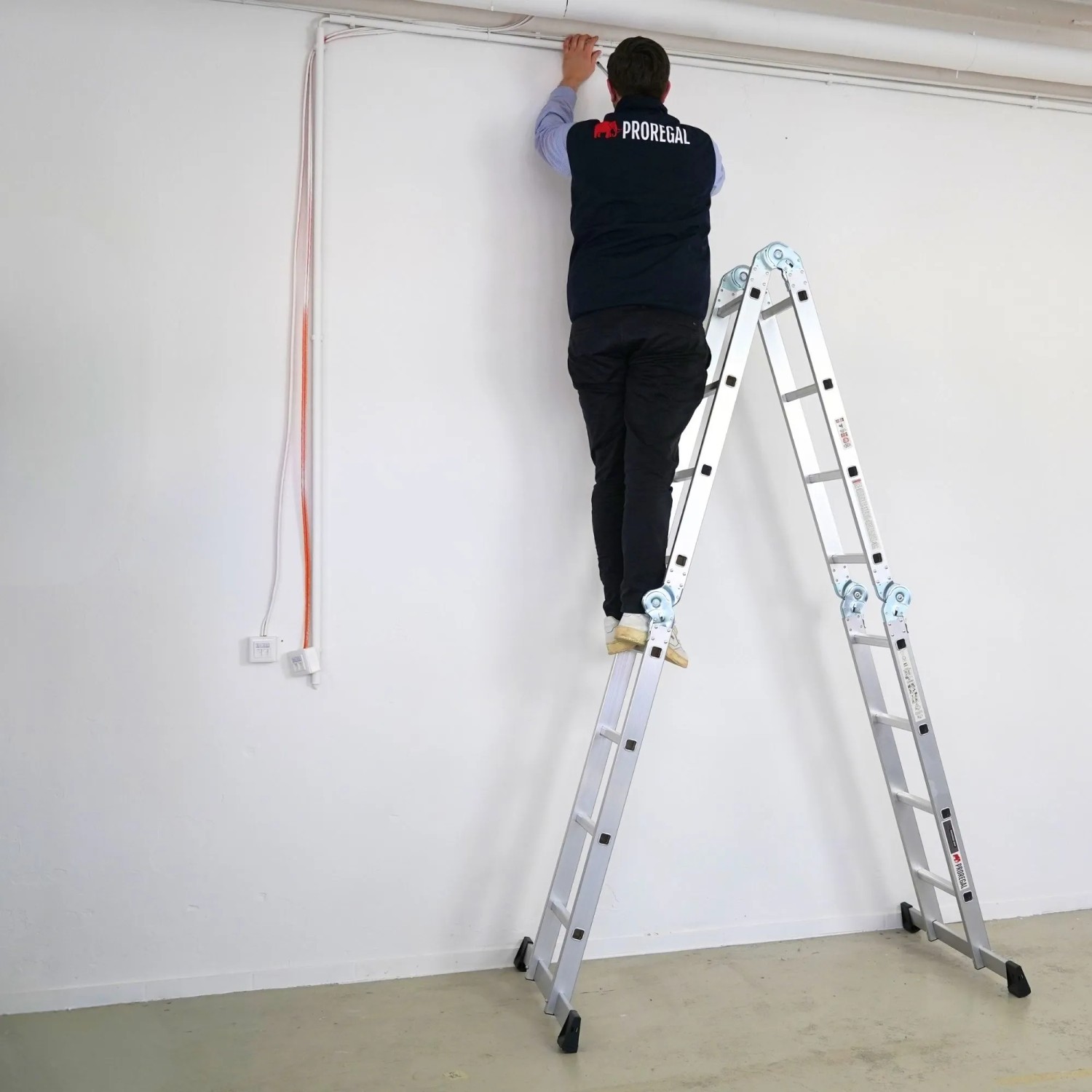 PROREGAL Mehrzweckleiter MULTISTEP als Stehleiter mit Person bei Montagearbeiten.