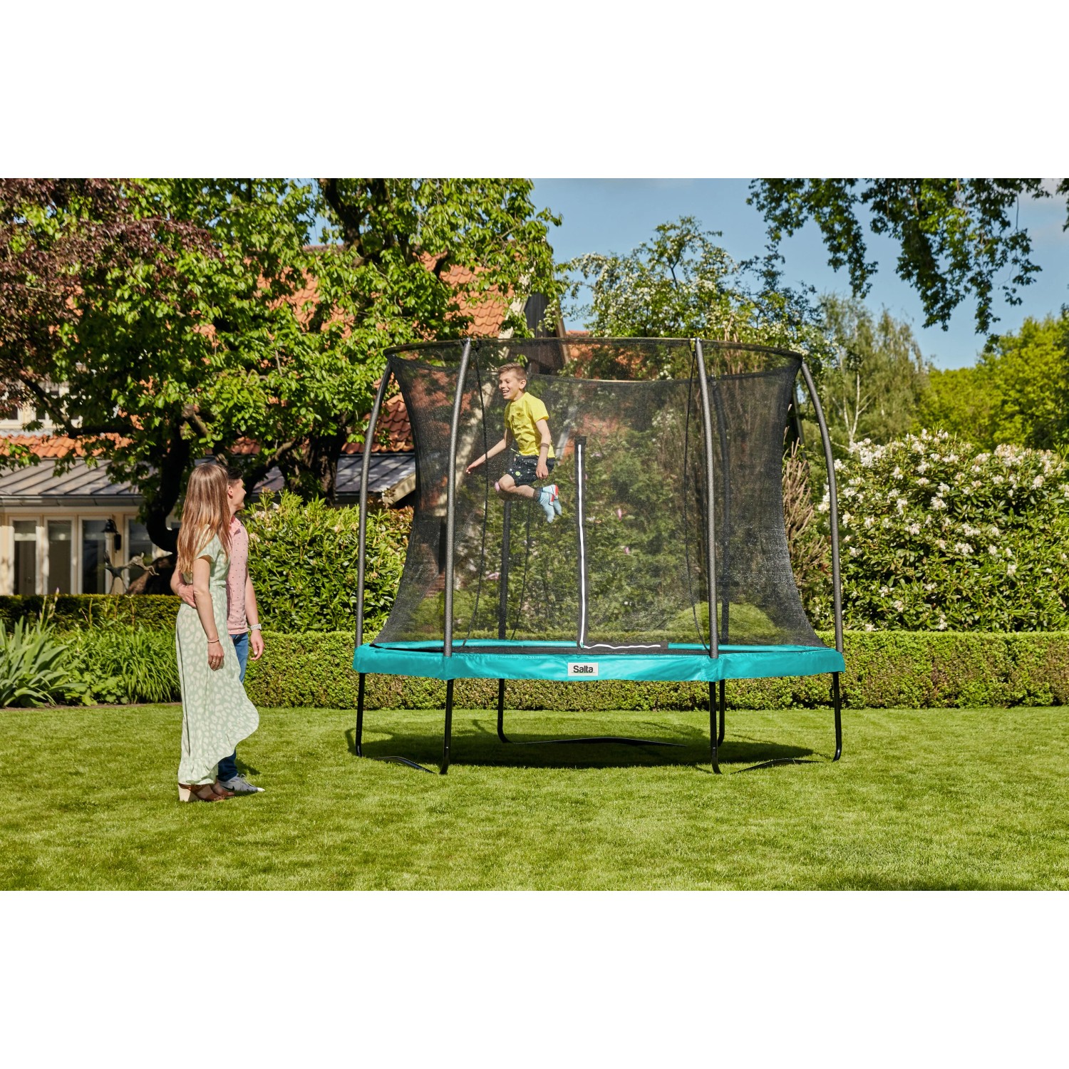 Grünes Salta Trampolin Comfort Edition ø 153 cm mit Sicherheitsnetz im Garten.