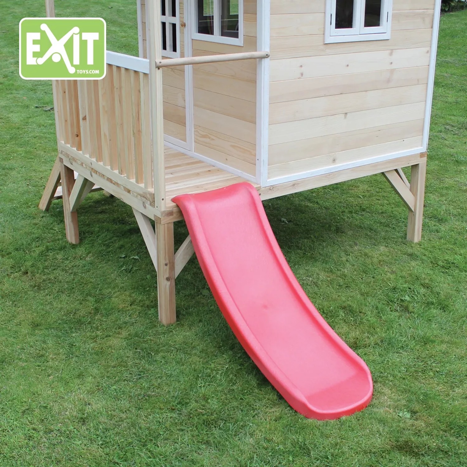 EXIT Loft 300 Holzspielhaus naturel mit roter Rutsche im Garten.