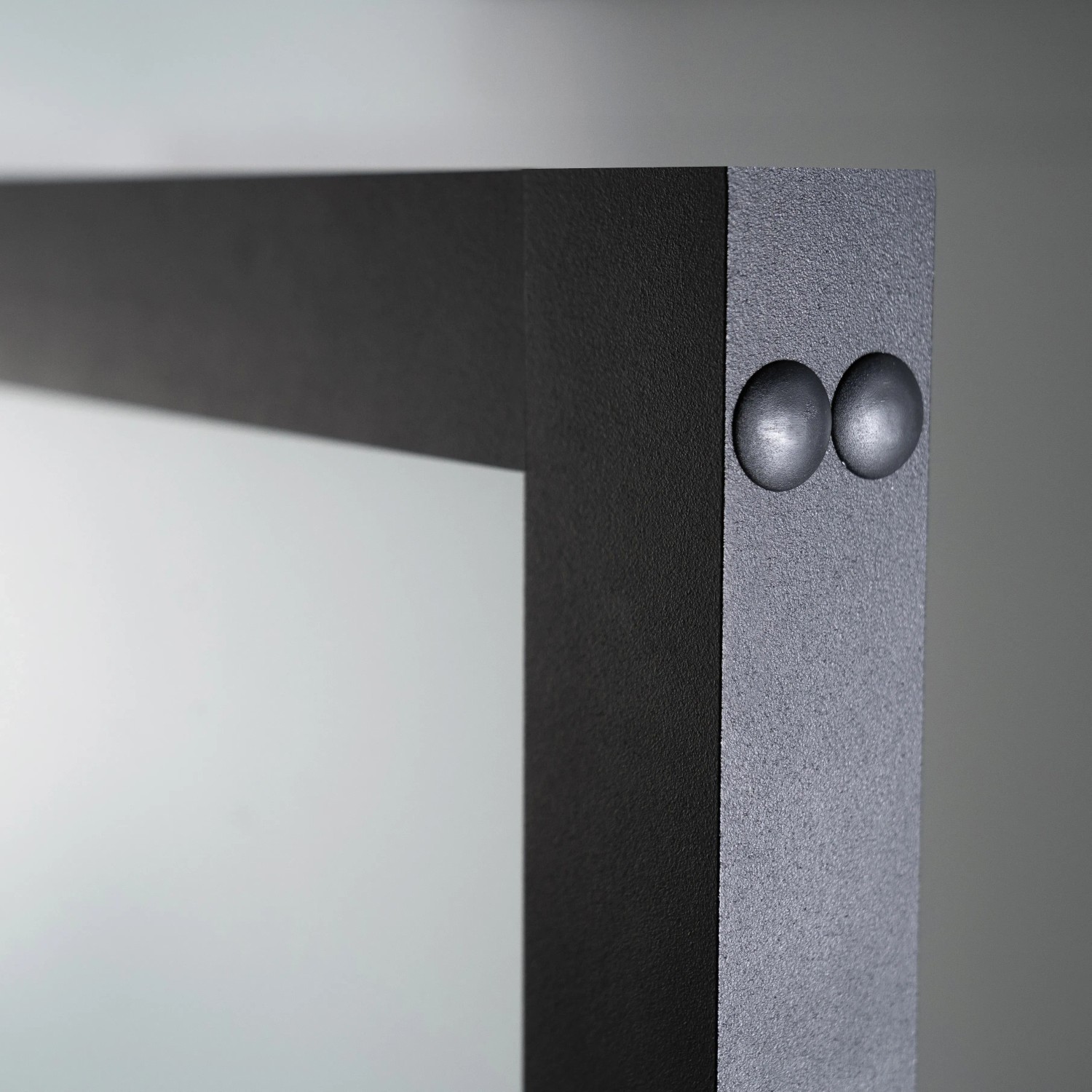 Detailaufnahme: Schwarze Blockzarge der Loft+Mehr Drehtür aus Glas, mit Beschlägen.