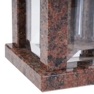 Nahaufnahme einer viereckigen Grablampe aus poliertem Granit Vanga mit rötlich-brauner Maserung und Glas.