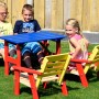 Mehrfarbige Kindersitzgarnitur von Dobar, 4-teilig mit Tisch, aus FSC®-zertifiziertem Holz. Kinder sitzen darauf im Garten.