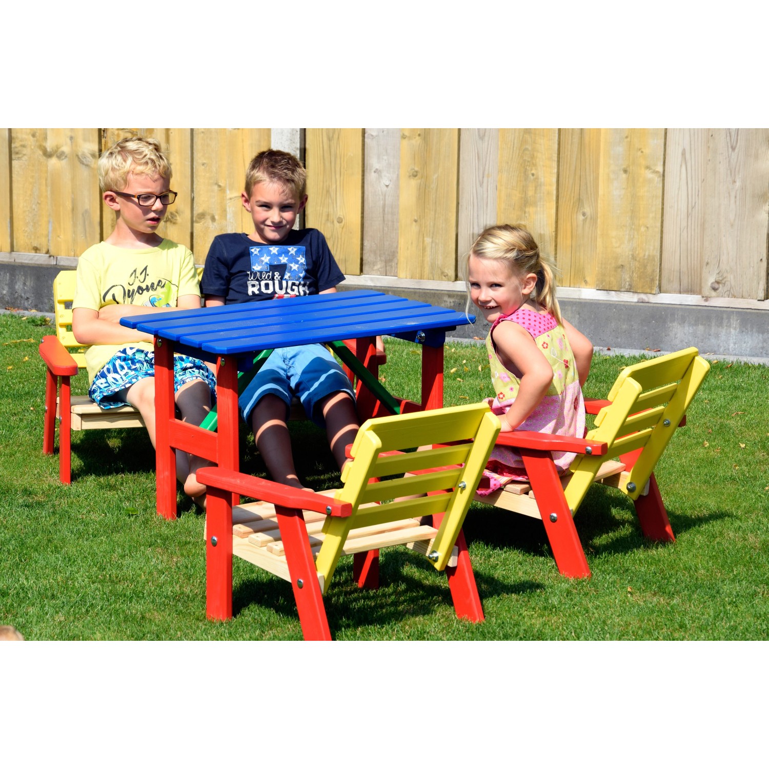 Mehrfarbige Kindersitzgarnitur von Dobar, 4-teilig mit Tisch, aus FSC®-zertifiziertem Holz. Kinder sitzen darauf im Garten.